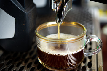 Closeup coffee machine making fresh espresso coffee into a cup with blurred background.