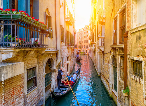Narrow canal with gondola and bridge in Venice, Italy. Architecture and landm...