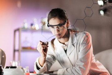 Fototapete - Portrait of a confident female health care expert in life science laboratory writing structural chemical formula on a glass board. Healthcare and modern life science concept. Blue toned image.