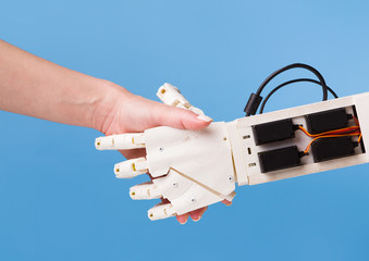 Robot and human handshake. Cooperation of people and technology.