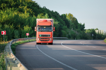 Wall Mural - Arriving white truck on the road in a rural landscape at sunset