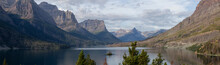 Beautiful Panoramic View Of A Glacier Lake With American Rocky Mountain Landscape In The Background During A Cloudy Summer Morning. Taken In Glacier National Park, Montana, United States.