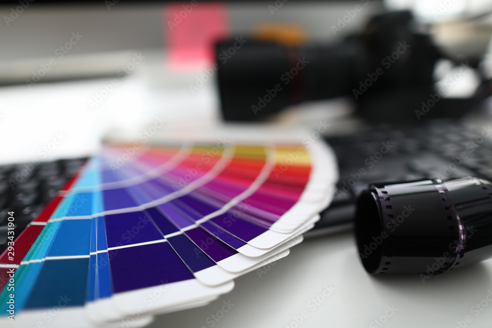 Color palette camera and keyboard are on white table in office. Correct ...