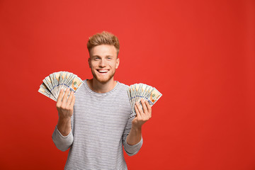 Wall Mural - Portrait of happy lottery winner with money on red background