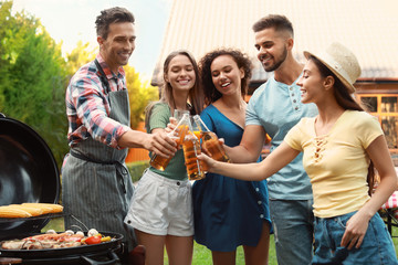 Wall Mural - Group of friends with drinks near barbecue grill outdoors