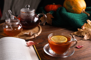 Cup of hot drink and book on wooden table. Cozy autumn atmosphere