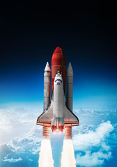 Leinwandbilder - Space shuttle launch in outer space from Earth. Rocket on orbit of the planet. Border of blue sky with clouds and dark deep space. .Elements of this image furnished by NASA	