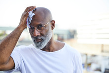 Portrait Of Mature Man Wiping His Bald On Hot Summer Day