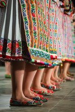 Close Up Of Legs Of Young Romanian Female Dancers In Traditional Folkloric Costume. Folklore Of Romania