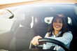 canvas print picture - Beautiful young happy smiling woman driving her new car at sunset. Woman in car. Close up portrait of pleasant looking female with glad positive expression, woman in casual wear  driving a car