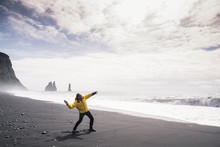 Mature Man Throwing A Stone Into The Sea, On A Lava Beach In Iceland
