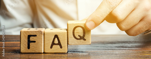 Photographie Businessman puts wooden blocks with the word FAQ (frequently asked questions)