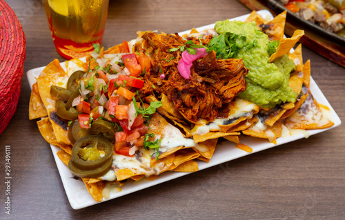 Fotografía Corn chips nachos with homemade guacamole sauce, meat, cheese