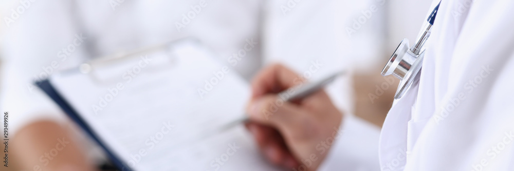 Male doctor hand hold silver pen and showing pad. Physical agreement form signature disease prevention ward round reception consent contract sign prescribe remedy healthy lifestyle concept - obrazy, fototapety, plakaty 