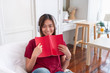 © weedezign - Asian woman listening music on headphone and reading book with relax pose at couch in living room at home.leisure lifestyle