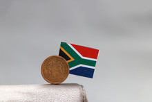One Coin Of South African Rand Money And Mini South African Flag Stick On The Leather Wallet On Grey Background.