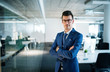© Halfpoint - A portrait of young businessman standing in an office, arms crossed.