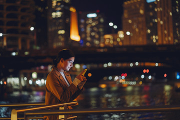 young brunette girl standing at night by Chicago skyline