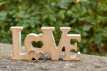 wedding rings with wooden word love