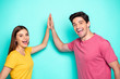 Portrait of his he her she nice attractive charming content overjoyed cheerful cheery couple giving five win winners isolated over bright vivid shine vibrant green turquoise background
