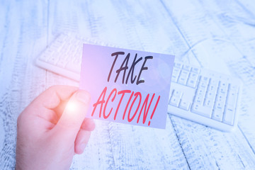 Text sign showing Take Action. Business photo showcasing do something official or concerted to achieve aim with problem man holding colorful reminder square shaped paper white keyboard wood floor