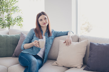 Poster - Photo of pretty redhead lady holding hot beverage in hand dreamy remembering romance date sitting comfy on sofa wearing jeans clothes homey in apartment