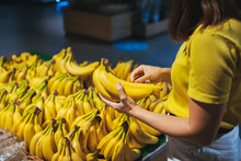 Woman Taking Yellow Bananas From The Store Shelf