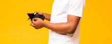 Empty Wallet In Black Man Hands On Yellow Background