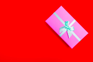 Poster - blue pink box with blue ribbon on a red background.