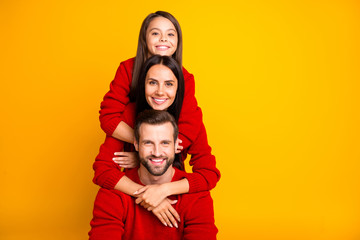 Poster - Photo of cheerful day charming fun funky positive family in red sweaters piggyback hugging each other smiling toothily enjoying spending free time with each other isolated vivid color yellow