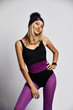 © Dmitry Lobanov - Stylish woman in purple sports wear, smart watches and winter hat is standing and smiling prankingly