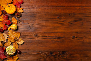 Wooden background. Arranged autumn leaves and pumpkins. Top view.