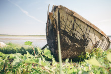 Old Broken Boat On The River Bank On A Sunny Day