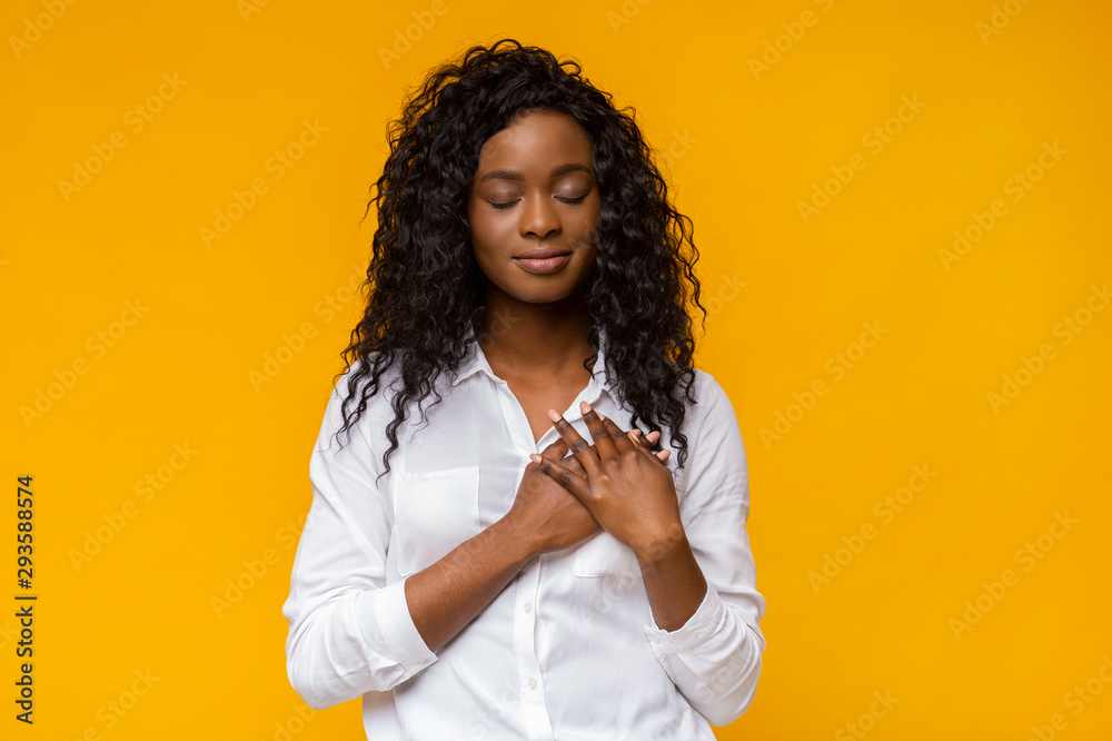 Appreciative afro woman placing hands on her heart - obrazy, fototapety, plakaty 