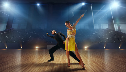 Wall Mural - Couple dancers  perform latin dance on large professional stage. Ballroom dancing.