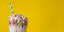 Close-up view of delicious milkshake with yellow background