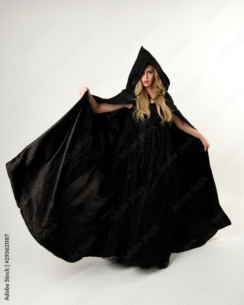 full length portrait of blonde girl wearing long black flowing cloak ...