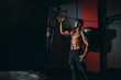 © VisionPro - Concentrated strong athletic man lift up the big hummer and wants to do strikes over a large tire in cross fitness class