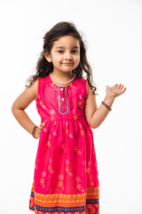 Portrait of cute little Indian girl model, standing isolated over white background 