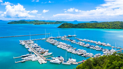 Wall Mural - Beautiful port yachts and boats in marina bay, Aerial view of yachts and boat in the marina clear water with blue sky background.