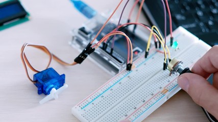 Microelectronic engineering. System programming. IT developer testing hardware with microcontroller.