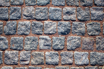 old wall of blue gray square stone bricks with red cement. rough surface texture