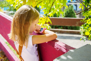 Modern technology for children. School girl using her GPS smart watch.  GPS kids tracker, kids tracking and parental control concept