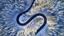 Overhead view of winding road in snow covered forest