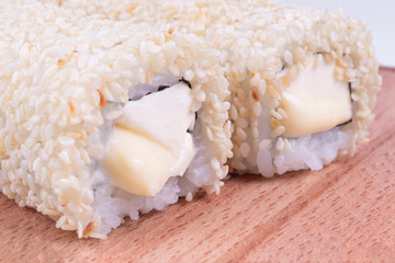 two rolls with cream cheese are beautifully lying on a wooden board. Japanese cuisine dish