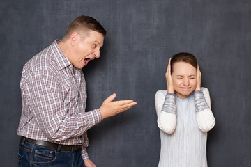 Wall Mural - Furious man is screaming on upset woman covering her ears