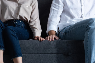 Wall Mural - partial view of man and woman sitting on sofa at home