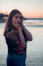 Young Latina Teen With Her Hands On Her Face At The Beach Sunset
