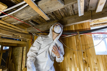Indoor Damp & Air Quality (IAQ) Testing. A Close Up View Of A Man At Work In Full PPE (personal Protective Equipment), Used To Protect From Airborne Mold Spores (aspergillus) During A Home Assessment.