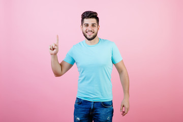 happy smiling handsome bearded man showing one finger isolated over pink